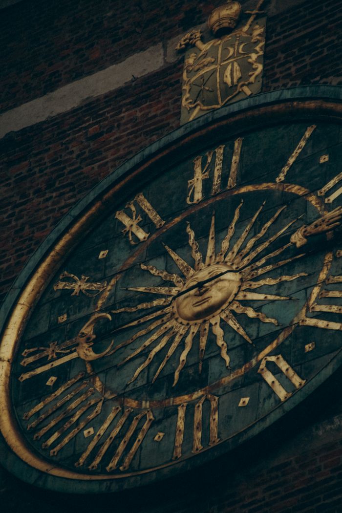 Home Close-up of an ancient astronomical clock face on a brick wall in Kraków, Poland.